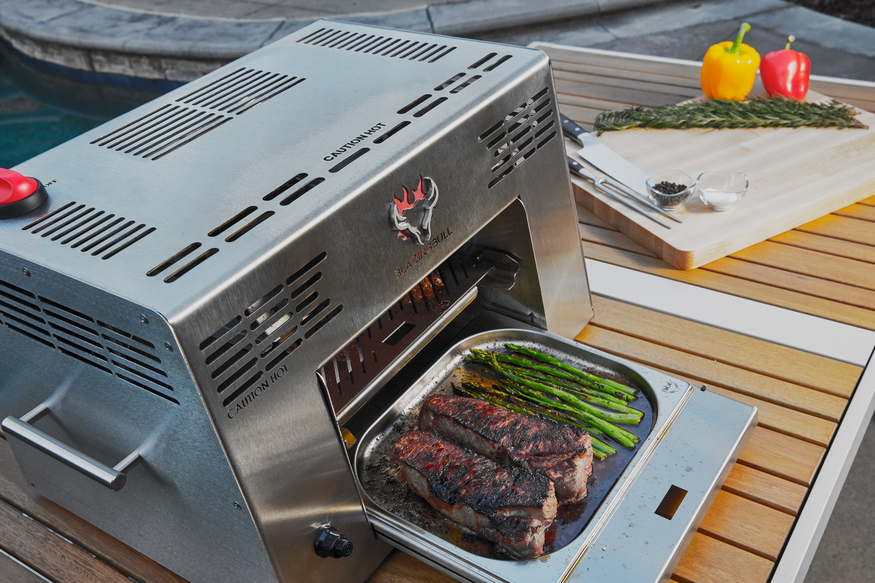 Blazing Bull with steaks and asparagus sitting in the drip tray